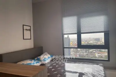 Modern bedroom with city view, featuring stylish decor and large window for natural light.