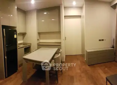 Modern kitchen with sleek cabinetry and dining area in a contemporary apartment.