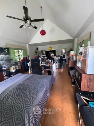 Spacious living room with high ceiling and modern decor, perfect for entertainment and relaxation.