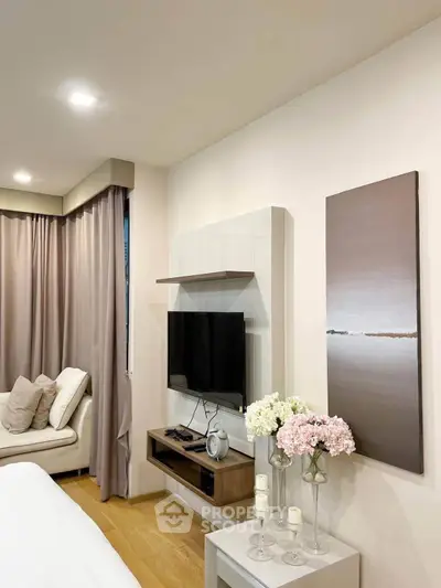 Modern living room with cozy decor and wall-mounted TV, perfect for relaxation.