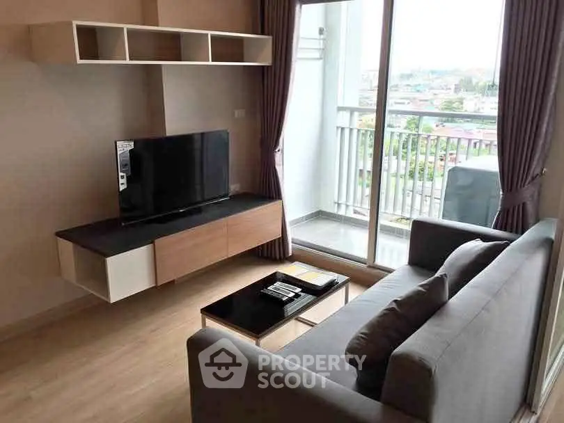 Modern living room with balcony view, sleek furniture, and natural light.