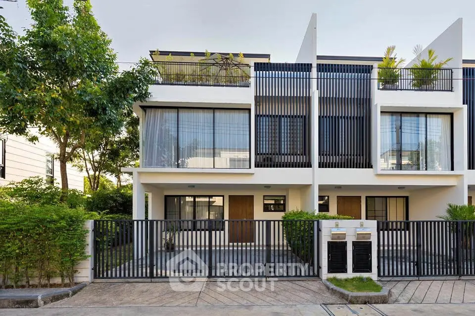 Modern townhouse exterior with sleek design and lush greenery