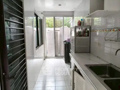 Bright kitchen with white tiles and large windows for natural light