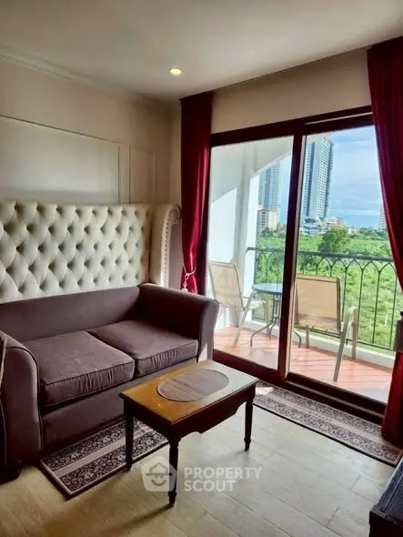 Charming living room with plush sofa and balcony view of cityscape
