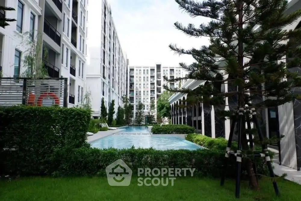 Modern apartment complex with lush garden and inviting swimming pool