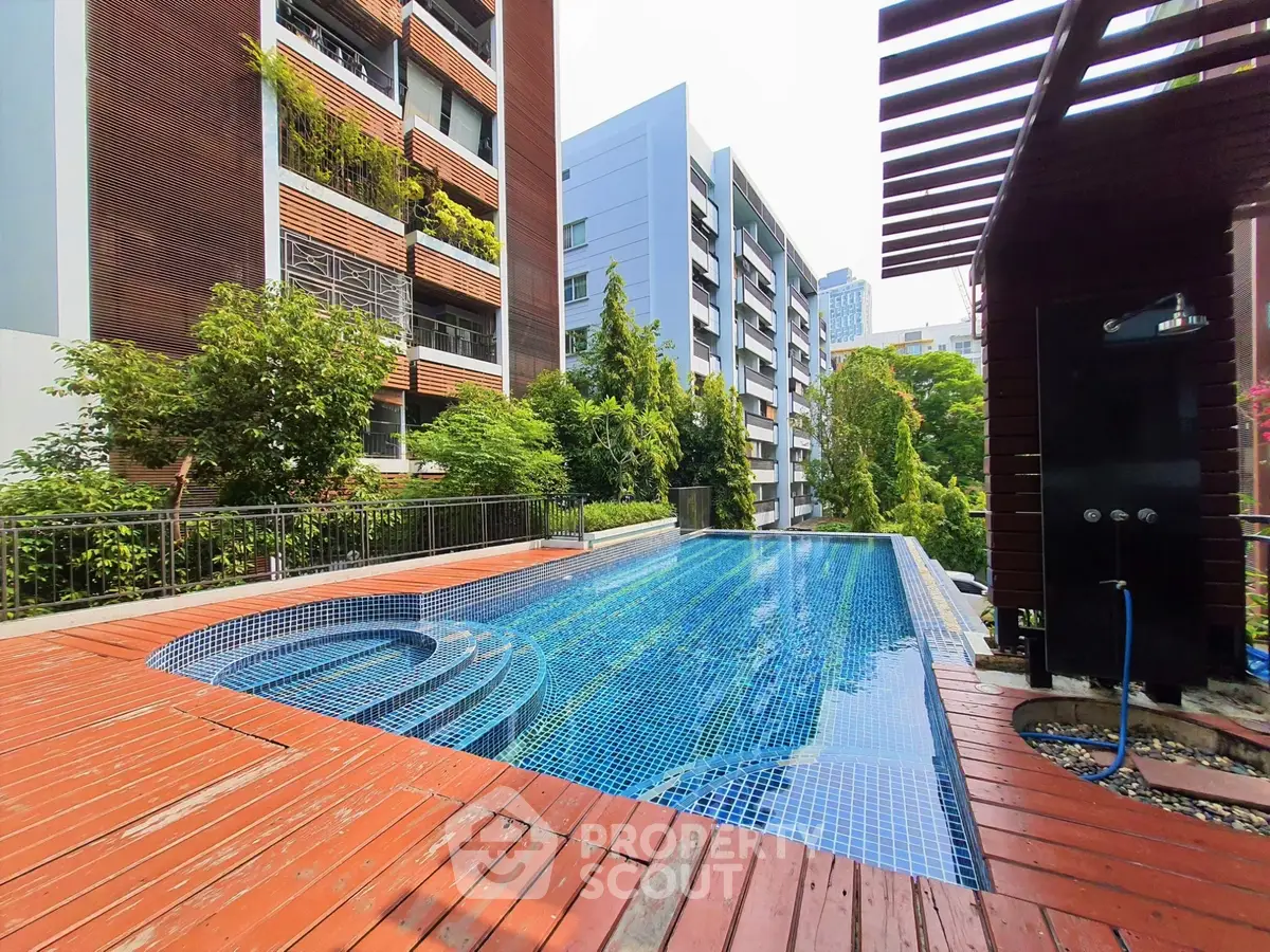 Luxurious apartment complex with stunning outdoor pool and lush greenery.