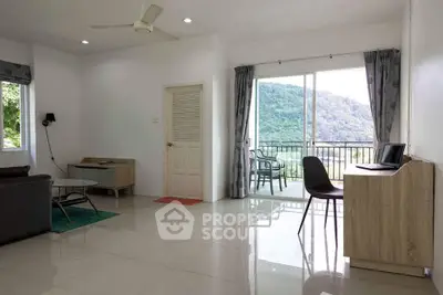 Spacious living room with mountain view and balcony access, featuring modern furniture and natural light.