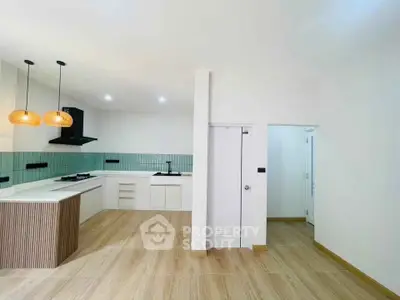 Modern kitchen with open layout and stylish lighting in a spacious apartment.