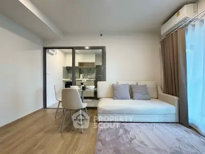 Modern living room with cozy sofa and dining area in open layout apartment.