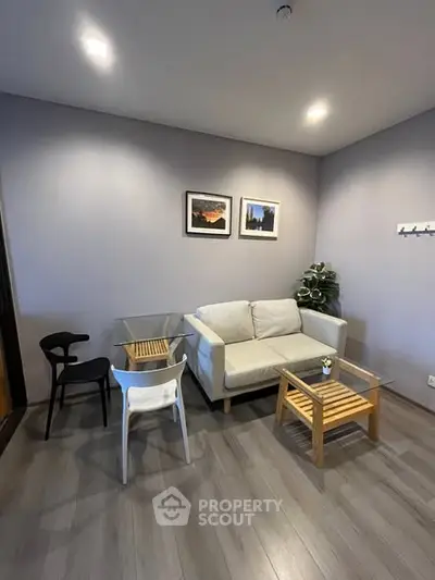 Modern living room with cozy sofa, stylish chairs, and elegant decor in a contemporary apartment.