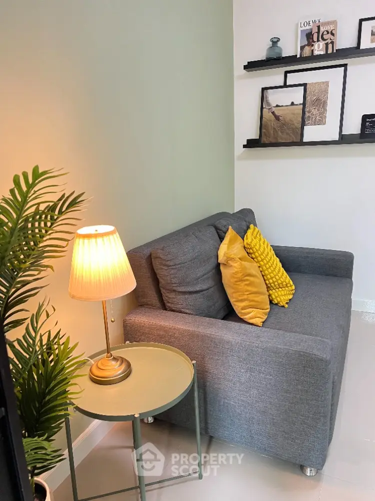 Cozy living room with stylish gray sofa and decorative pillows, perfect for relaxation.