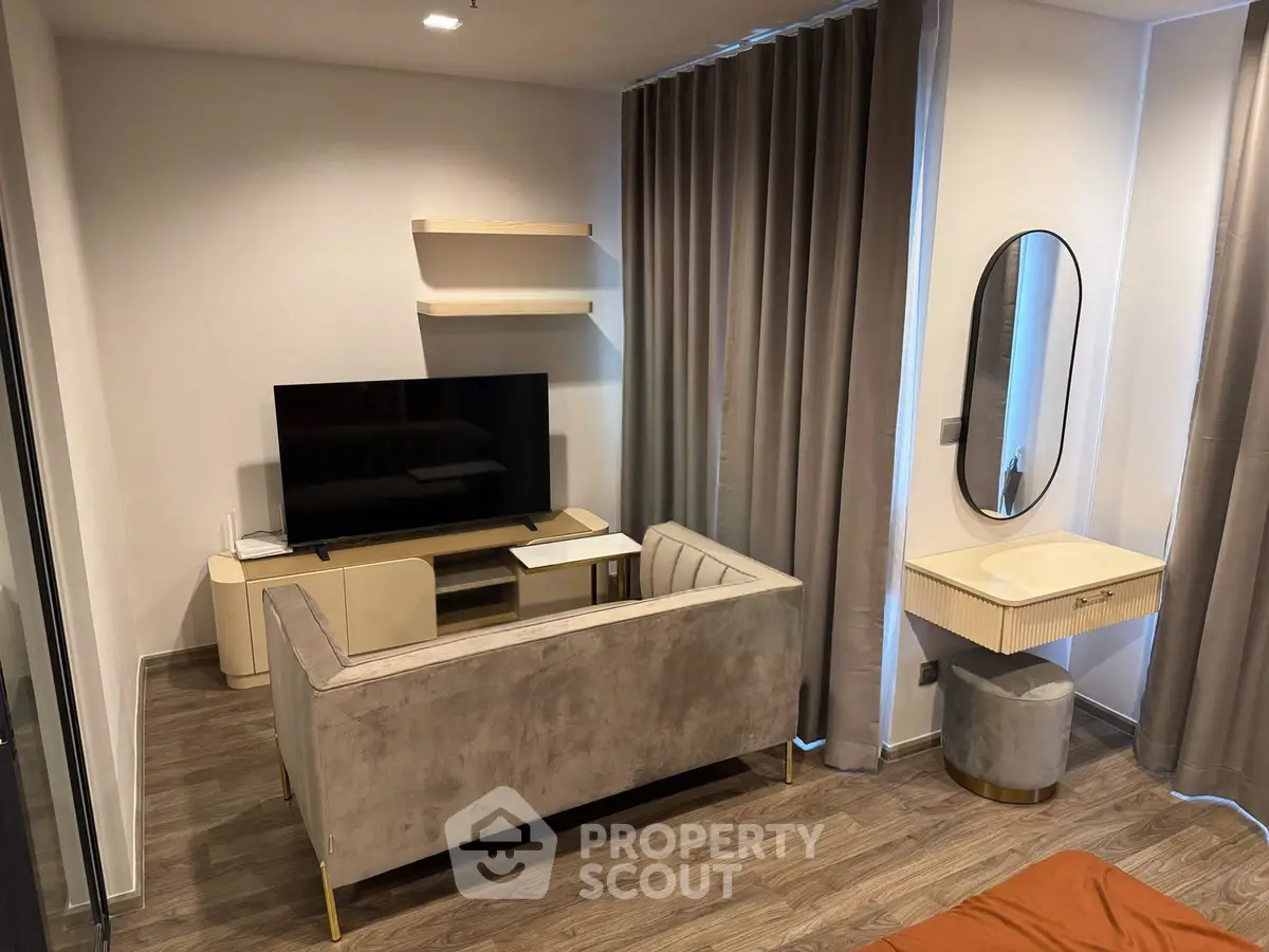 Modern living room with sleek furniture and stylish decor, featuring a wall-mounted TV and elegant curtains.