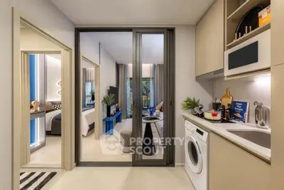 Modern apartment interior with sleek kitchen and cozy living area, featuring a washing machine and stylish decor.