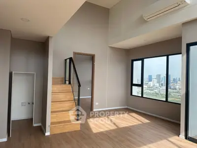 Spacious modern living room with city view and wooden staircase