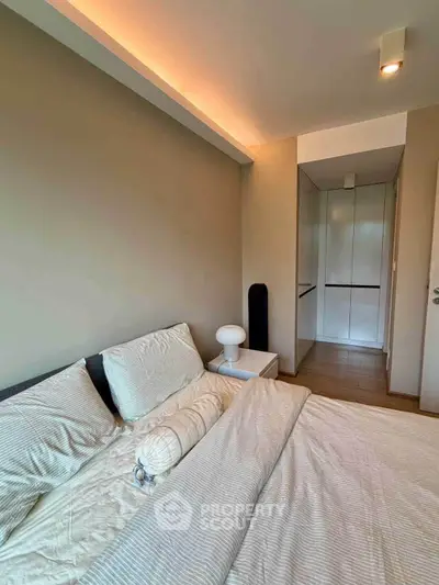 Modern bedroom with cozy bedding and sleek storage solutions.