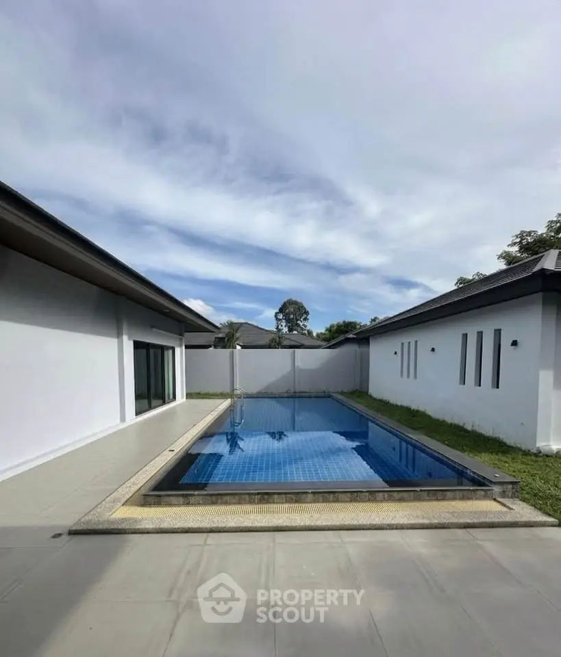 Modern villa with private pool and spacious outdoor area under a clear sky.