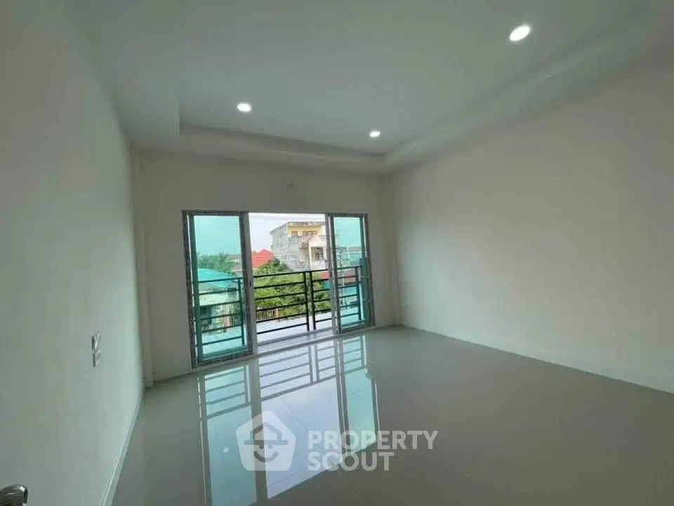 Spacious empty room with large windows and balcony view
