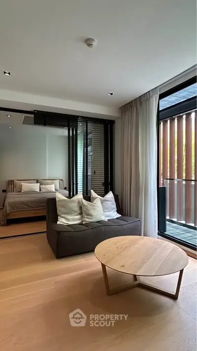 Modern living room with cozy seating and large windows in a stylish apartment.