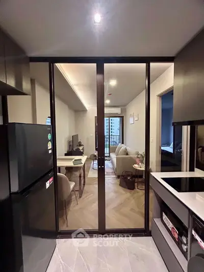 Modern open kitchen with sleek appliances and view into stylish living room