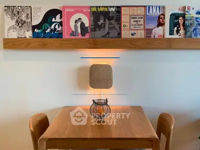 Stylish dining area with wooden table and chairs, featuring a modern wall shelf displaying vinyl records.