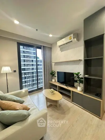 Modern living room with sleek furniture and large window offering city view