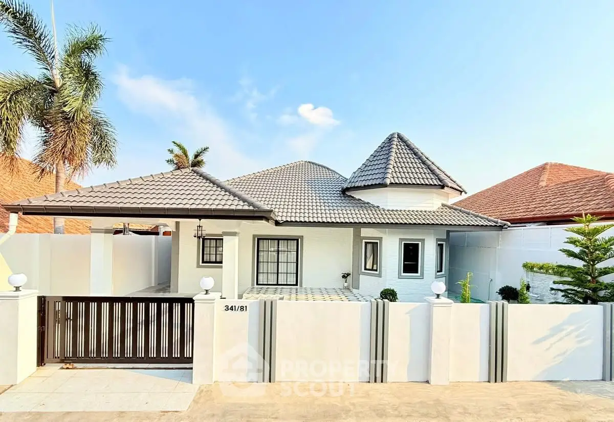 Charming single-story home with unique roof design and gated entrance in a serene neighborhood.