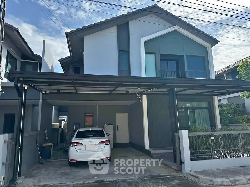 Modern two-story house with carport and sleek exterior design in a suburban neighborhood.