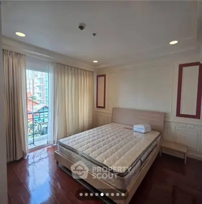 Spacious bedroom with large window and elegant decor in modern apartment