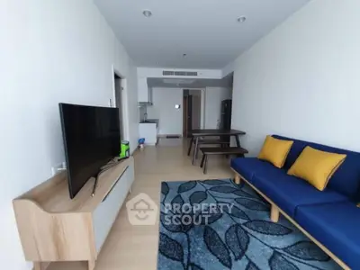 Spacious modern living room with blue sofa and large TV