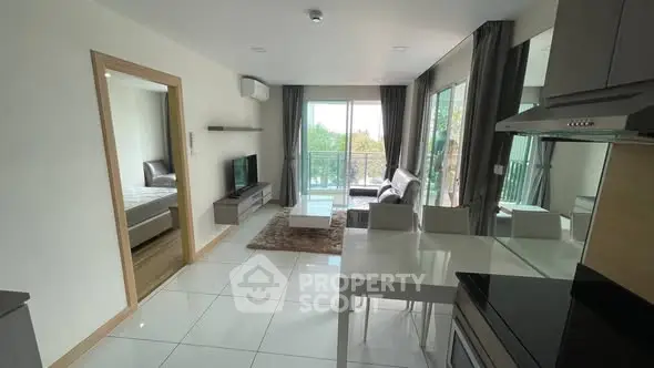 Modern open-plan living room with sleek kitchen and balcony view.