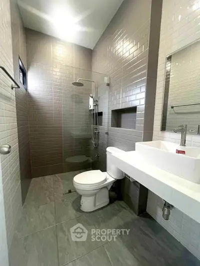 Modern bathroom with sleek tiles and glass shower enclosure