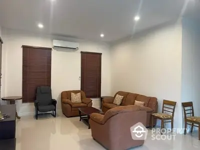 Spacious living room with cozy brown sofas and modern lighting, perfect for relaxation and entertainment.