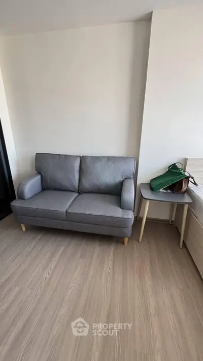 Modern living room with stylish gray sofa and wooden side table, perfect for cozy relaxation.