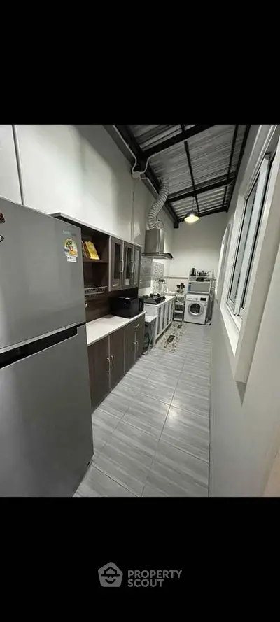 Modern kitchen with sleek appliances and ample storage in a stylish home.
