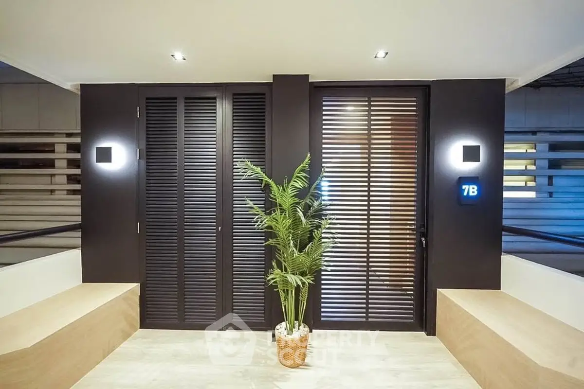 Modern apartment entrance with sleek design and potted plant decor.
