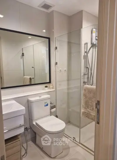 Modern bathroom with glass shower and sleek fixtures in a contemporary home.
