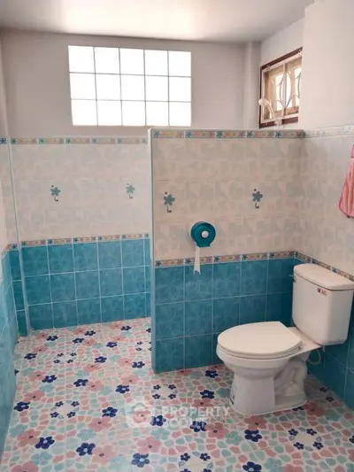 Charming bathroom with colorful tile design and natural light.