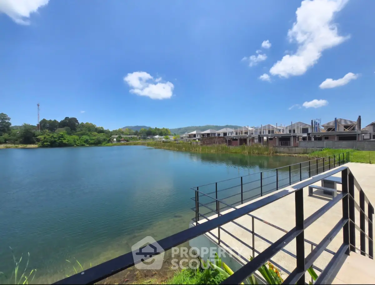 Stunning lakeside view with modern residential development under clear blue skies.