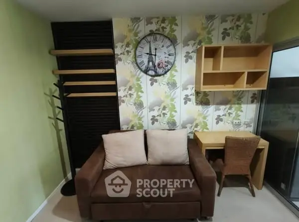 Cozy living room with brown sofa, wall clock, and wooden desk in modern apartment.
