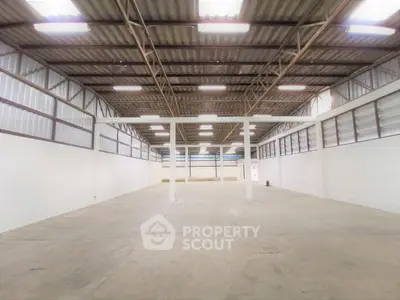 Spacious industrial warehouse with high ceilings and ample natural light.