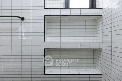 Modern bathroom with sleek white tiled shelves and window