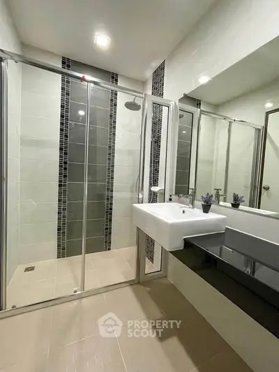 Modern bathroom with glass shower enclosure and sleek fixtures