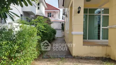 Charming suburban home with lush greenery and inviting pathway, perfect for family living.