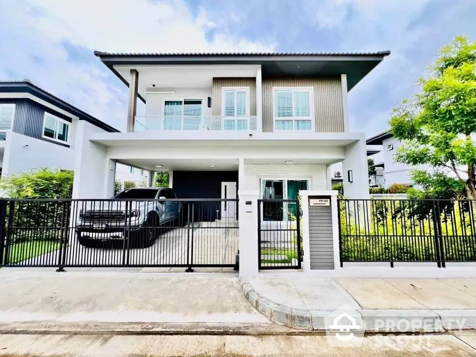 Modern two-story house with a sleek design, featuring a spacious driveway and lush greenery in a serene neighborhood.