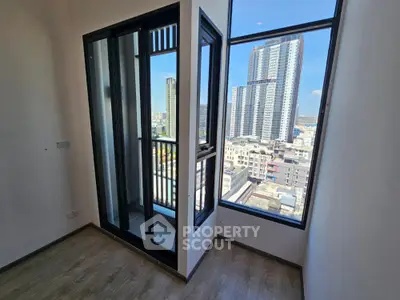 Bright and airy corner unit with expansive windows offering a panoramic city view, modern flooring, and access to a spacious balcony.