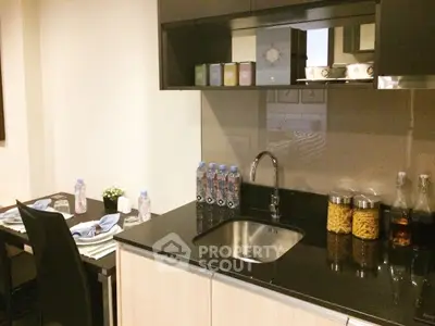 Modern kitchen with sleek black countertops and dining area, perfect for urban living.