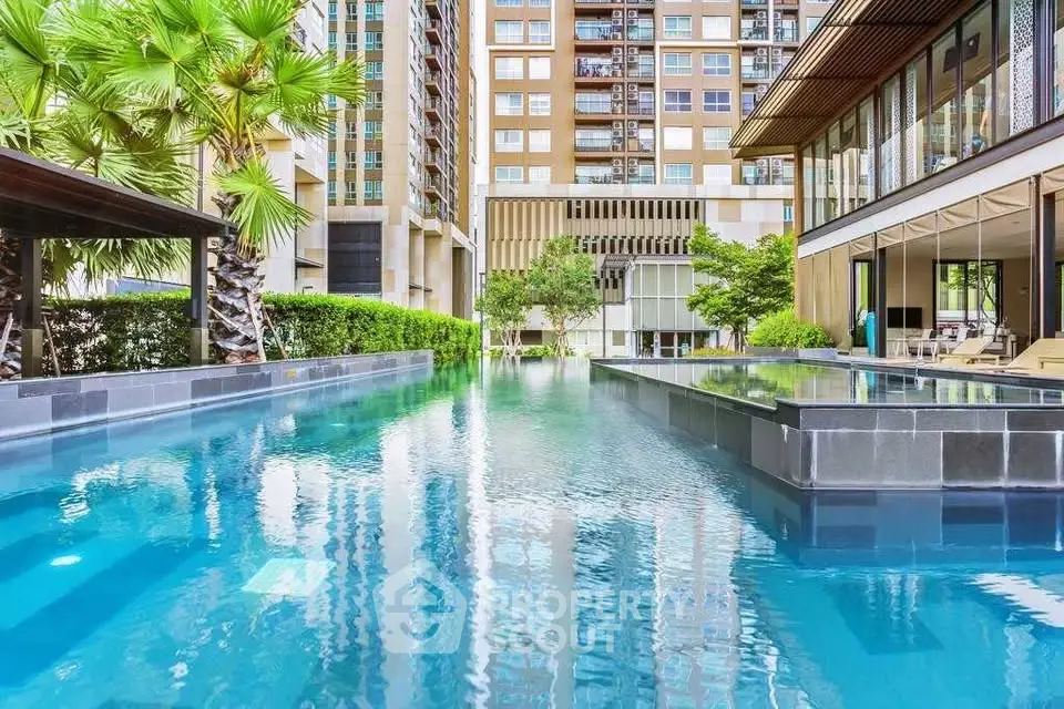 Luxurious condominium pool area with modern architecture and lush greenery