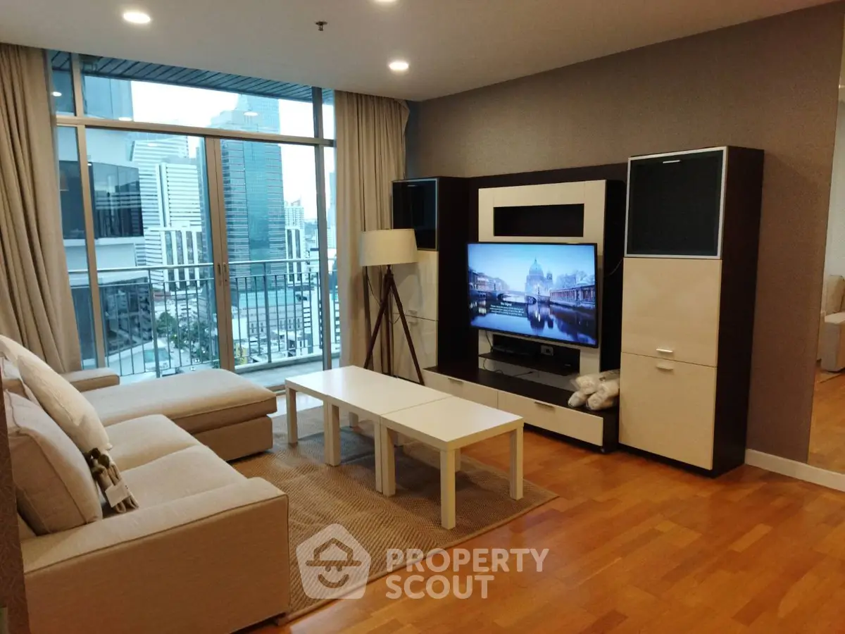 Modern living room with city view, stylish furniture, and large TV setup.