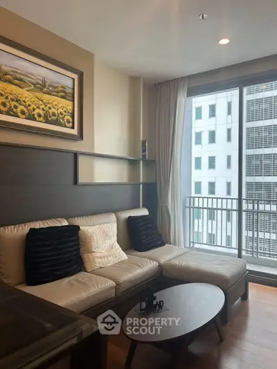 Modern living room with cozy sofa and city view balcony in a high-rise apartment.