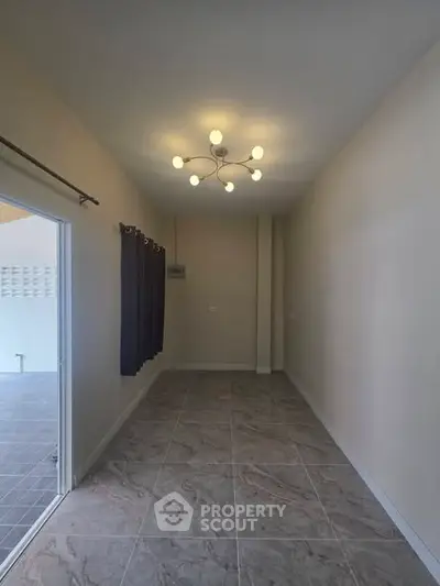 Spacious interior room with modern lighting and tiled flooring, ideal for versatile use.